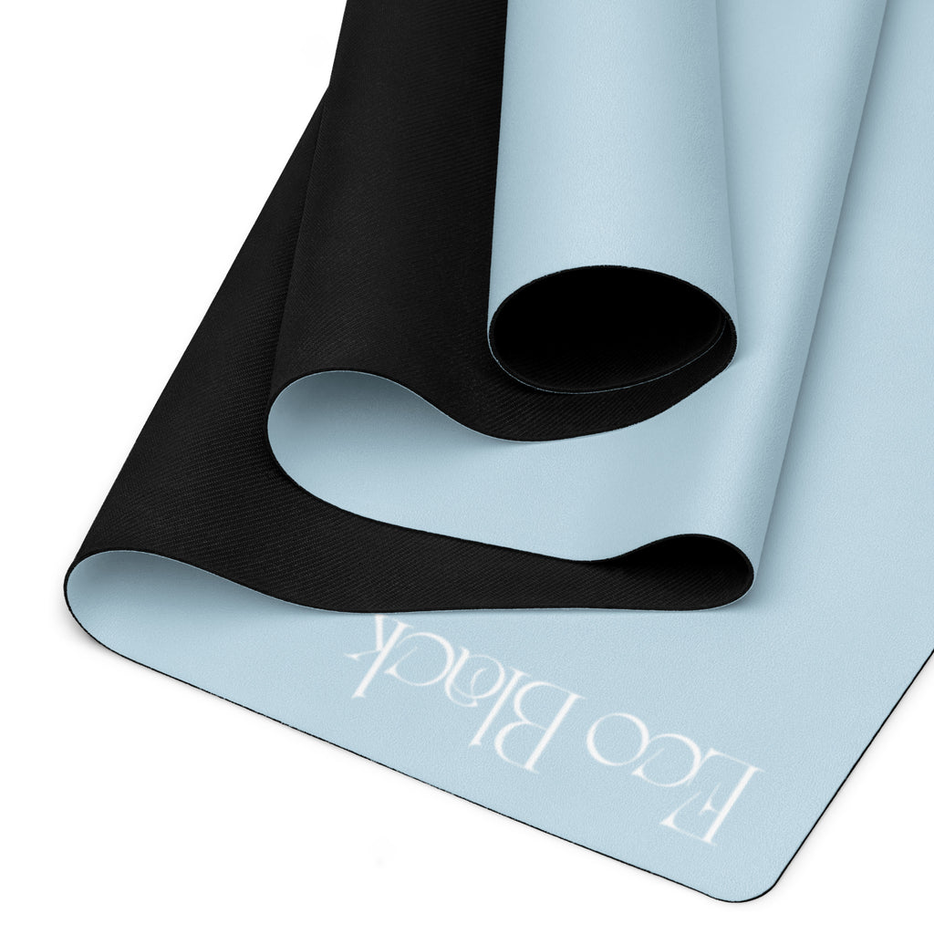 Powder blue yoga mat folded, showing black textured grip underside and EcoBlack mark.