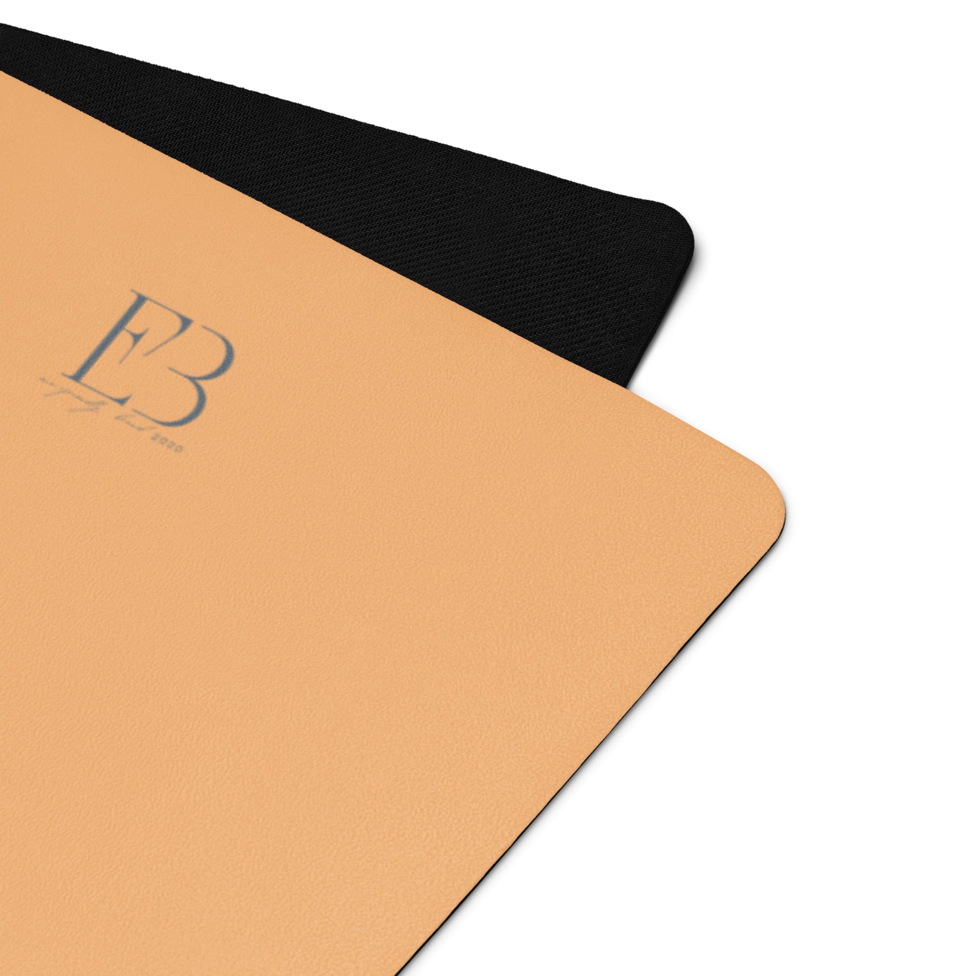 Corner close-up of a golden yoga mat with textured grip and E3 logo