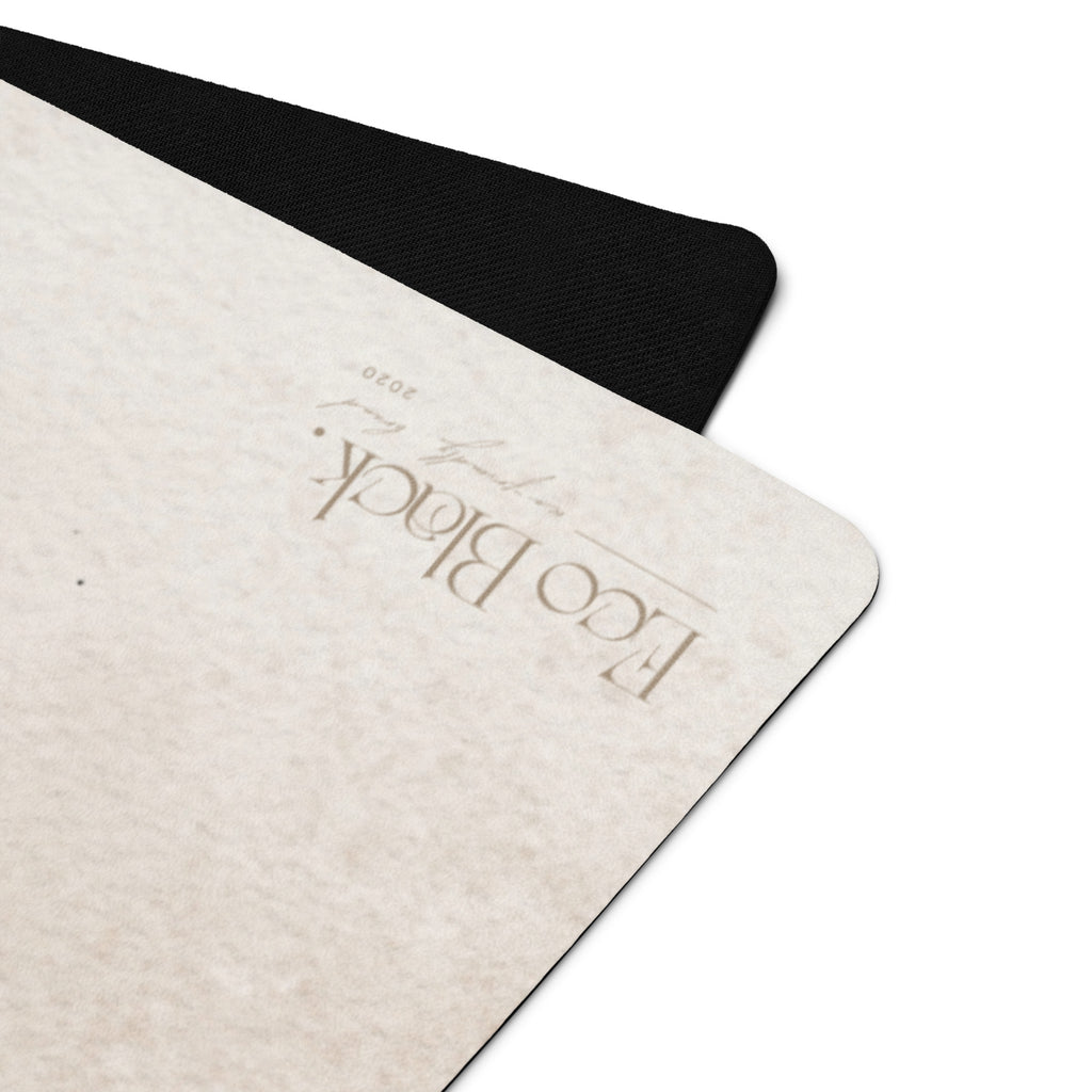 Close-up of light beige yoga mat corner with embossed brand text