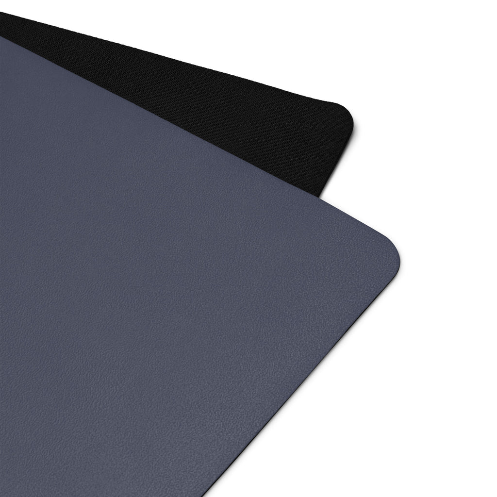 Slate blue yoga mat close-up showing textured surface and black edge binding