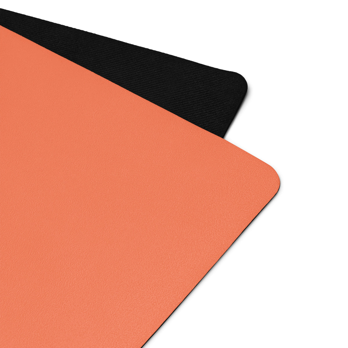 Orange yoga mat with a black textured edge along the corner seam.